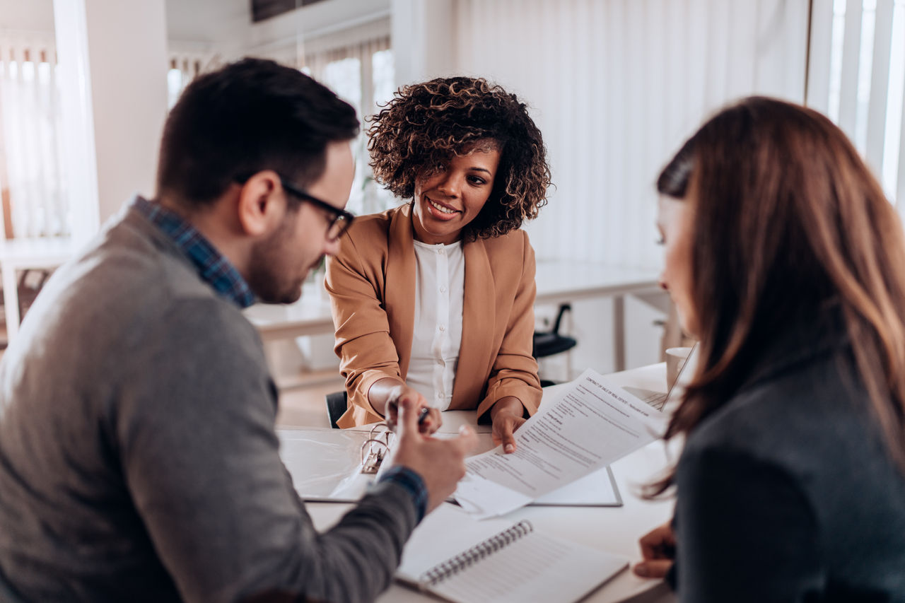 Woman handing couple paperwork to sign
