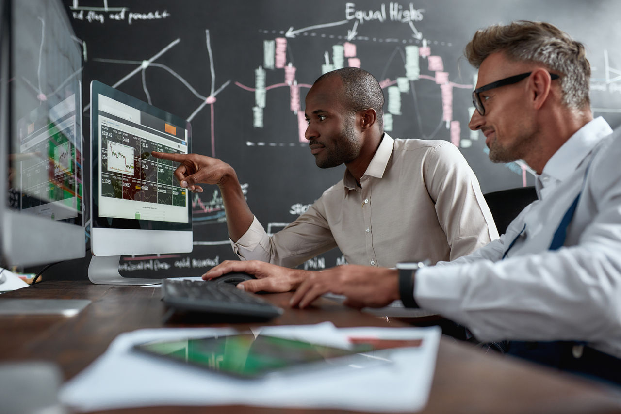 Two colleagues talking to each other, looking at graphs