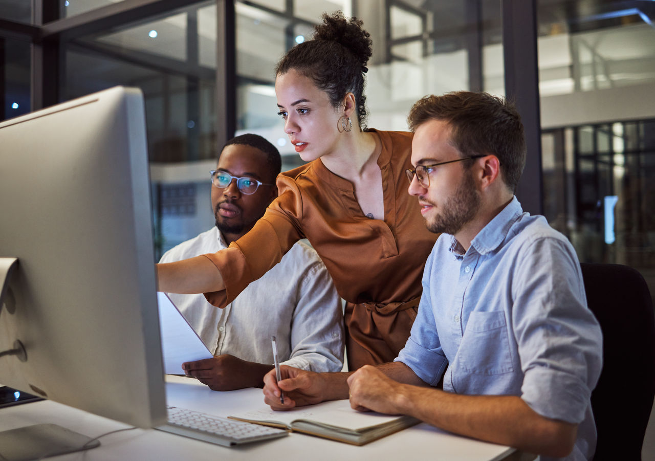 Data analysts looking at computer screen in office