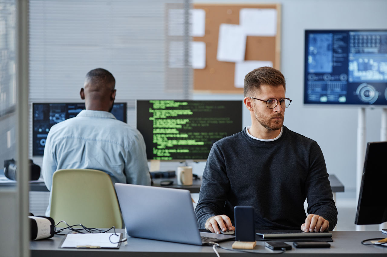 Data analyst looking at computer screen in office