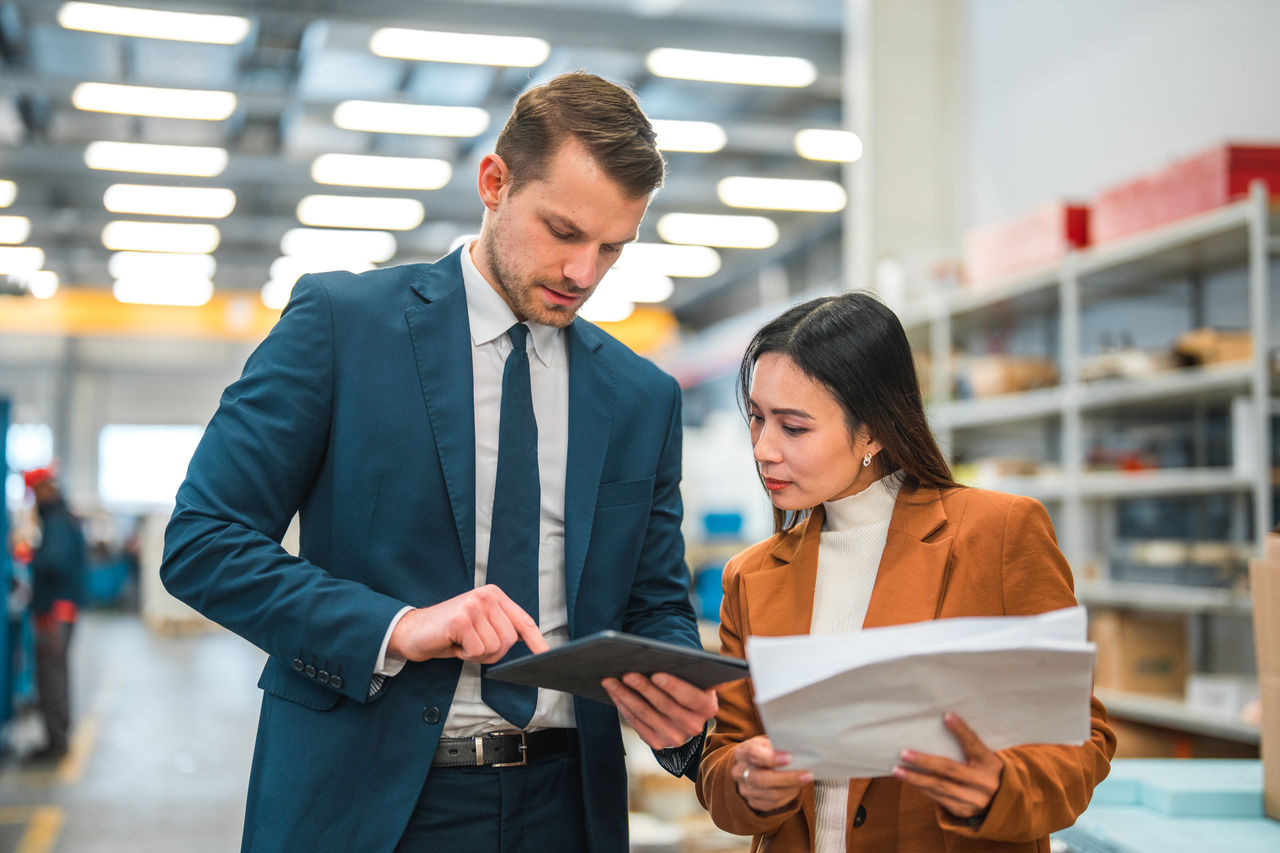 Warehouse managers in a business meeting looking at a touch screen tablet