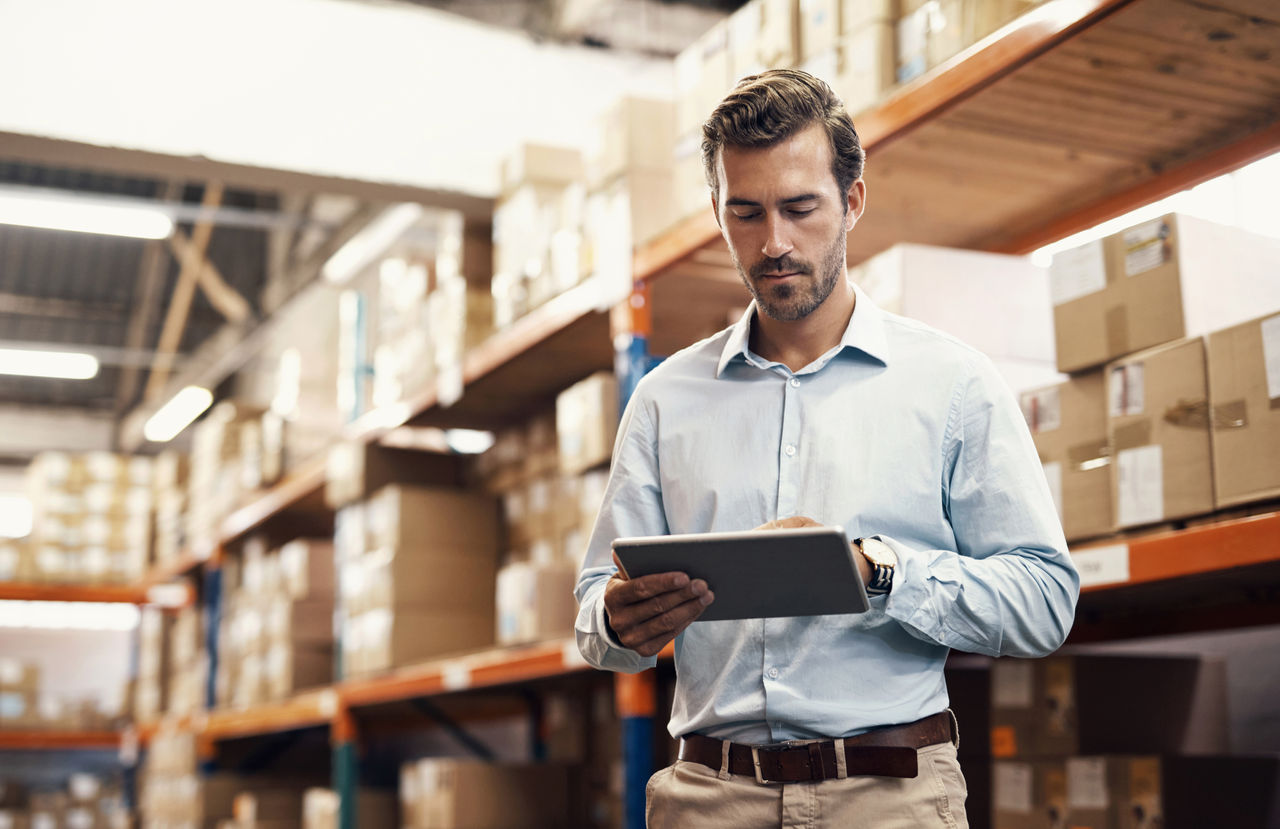 Shot of a man using a digital tablet while working in a warehouse