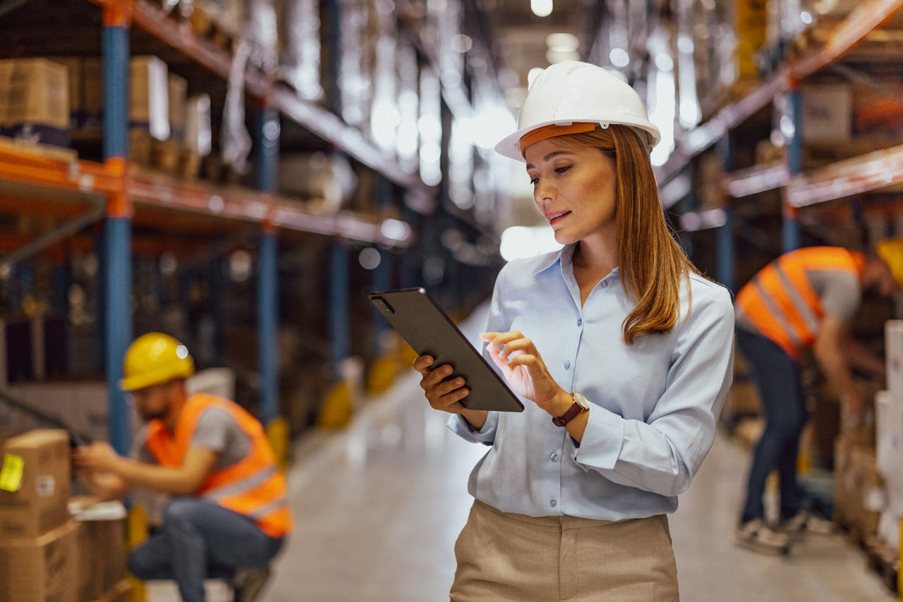 Portrait of female manager of a distribution warehouse, Woman supervising the operation of a distribution warehouse
