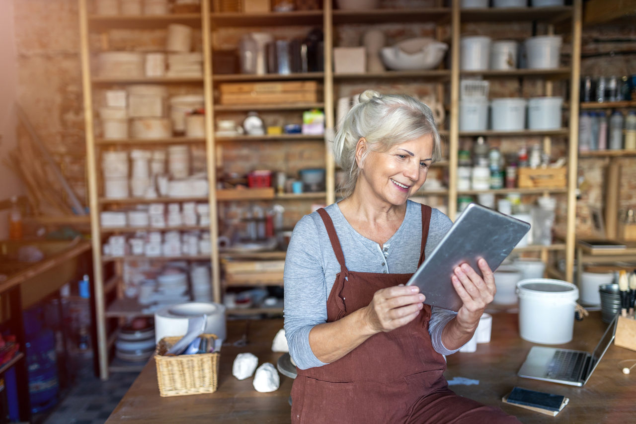 Small business owner woman checking tablet in her studio